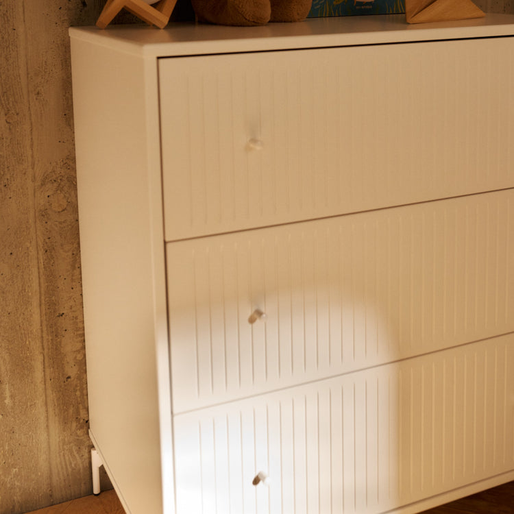 FLEXA. Συρταριέρα Saga με 3 συρτάρια και όψεις Grooves. Λευκό/ λευκά πόμολα/ λευκά πόδια.